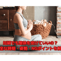 ヨガマットに座る妊婦の女性が整体に適した姿勢で呼吸を整えている様子