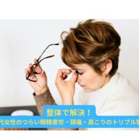 40代女性が眼精疲労により目の奥を押さえてつらそうにしている様子